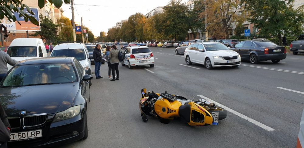 Un motociclist a intrat într-o mașină parcată încercând să evite o șoferiță neatentă la volan