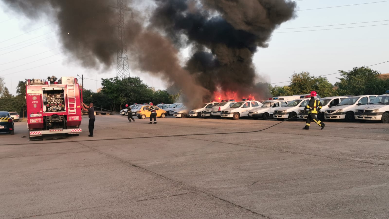 (Foto/video) Incendiu în parcarea Secției 5 de poliție Constanța. Un microbuz a ars și alte mașini au fost afectate