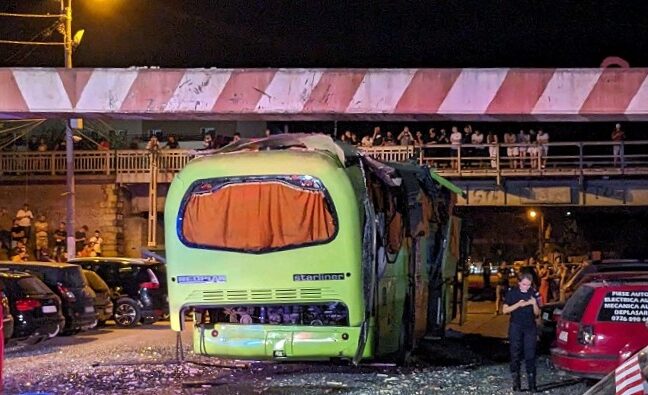 (FOTO) Zeci de gură cască stau cocoțați pe podul de lângă calea ferată din Năvodari pentru a privi mai bine autocarul „decapotat” de limitatorul de înălțime