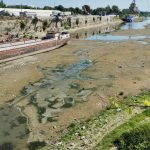 FOTO INCREDIBILE cu Dunărea, la minimum istoric: Vapoare și șlepuri blocate în noroi, firul de apă abia se vede